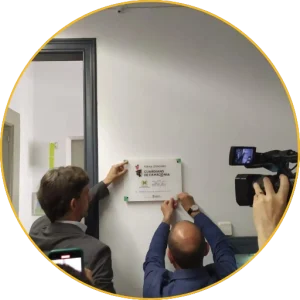A Guardian Schools Network plaque being put up while a camera films it