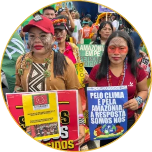 Dones indígenes amb cartells pel clima i l’Amazònia en una manifestació de la COP30
