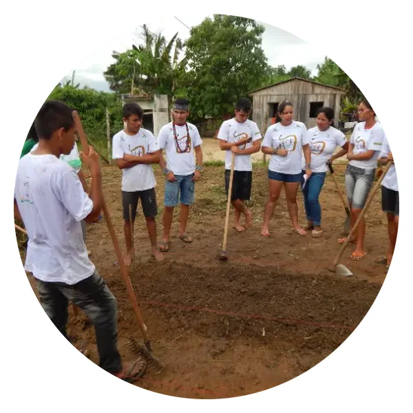 Young Puyanawa people preparing the soil for planting