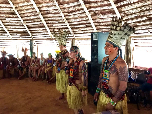 Puwe y cantores Puyanawa, con tocados de plumas, cantan en la gran maloca durante la grabación del disco