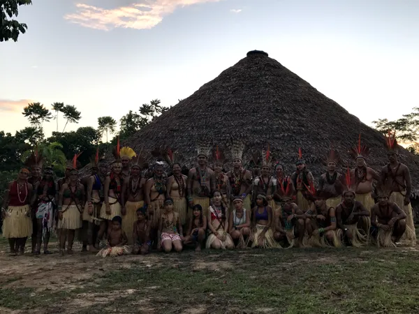 La comunidad Puyanawa reunida delante de la gran maloca al atardecer
