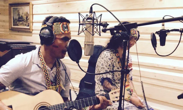 Puwe toca la guitarra y Vari canta en el estudio de grabación