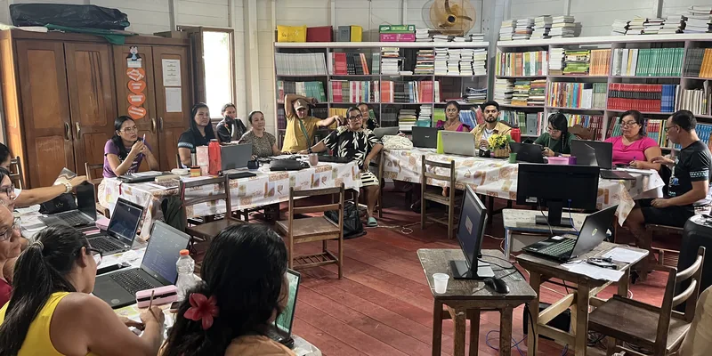 The Escola Ixubãy library full of teachers working on laptops during the training
