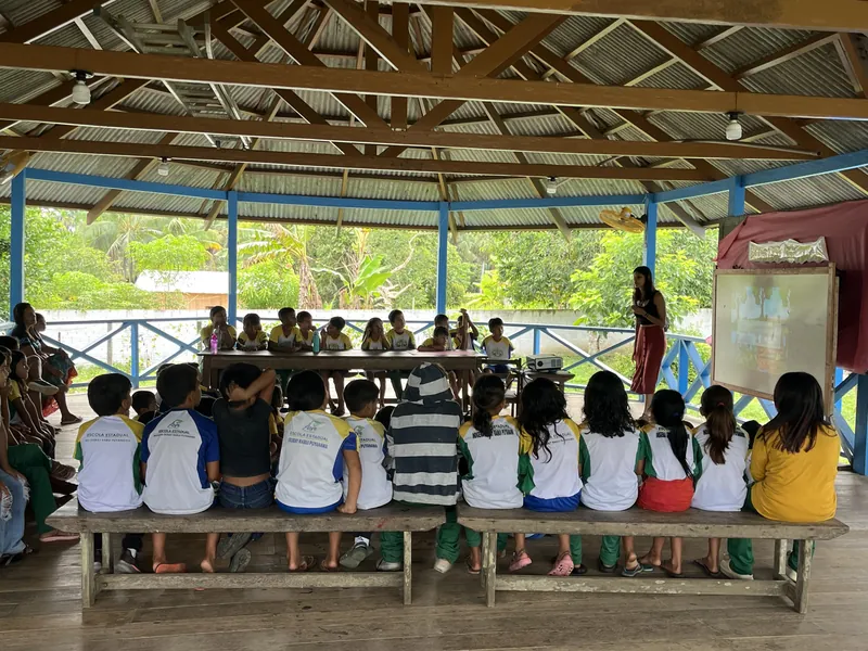 Students at the Escola Ixubãy seen from behind in the open classroom during a sustainability workshop