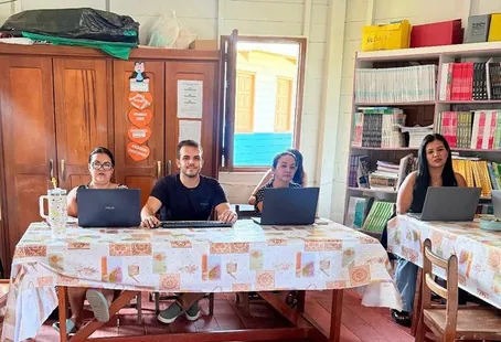El professor Jonas Anjos i tres educadores amb portàtils en una taula de l'aula