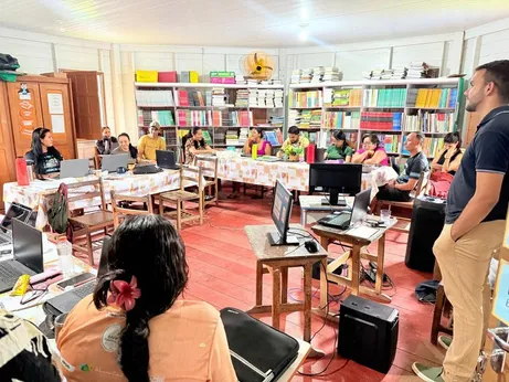 Educadors amb els seus portàtils a les taules de l'aula durant la formació