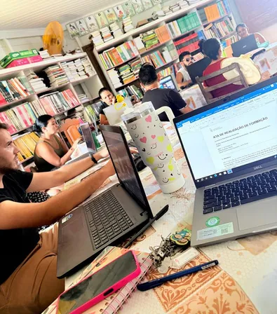 Educadores treballant amb portàtils a la biblioteca de l'escola
