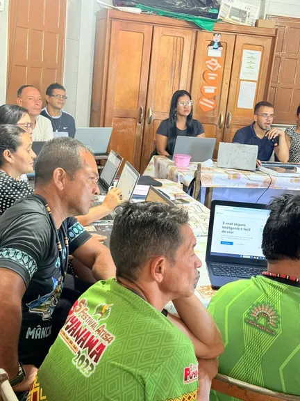 Educadors indígenes atents a la pantalla d'un portàtil durant la classe