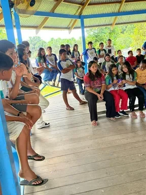 Estudiants i educadors asseguts sota la coberta de fusta seguint el taller